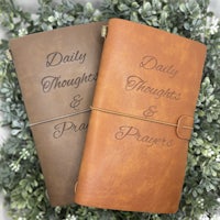 two leather journals with the words daily thought and prayer